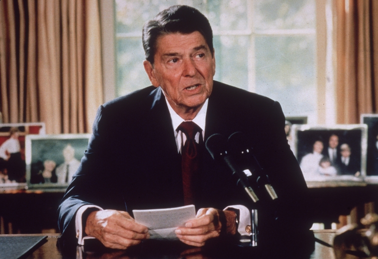 Ronald Reagan sits in the Oval Office of the White House.