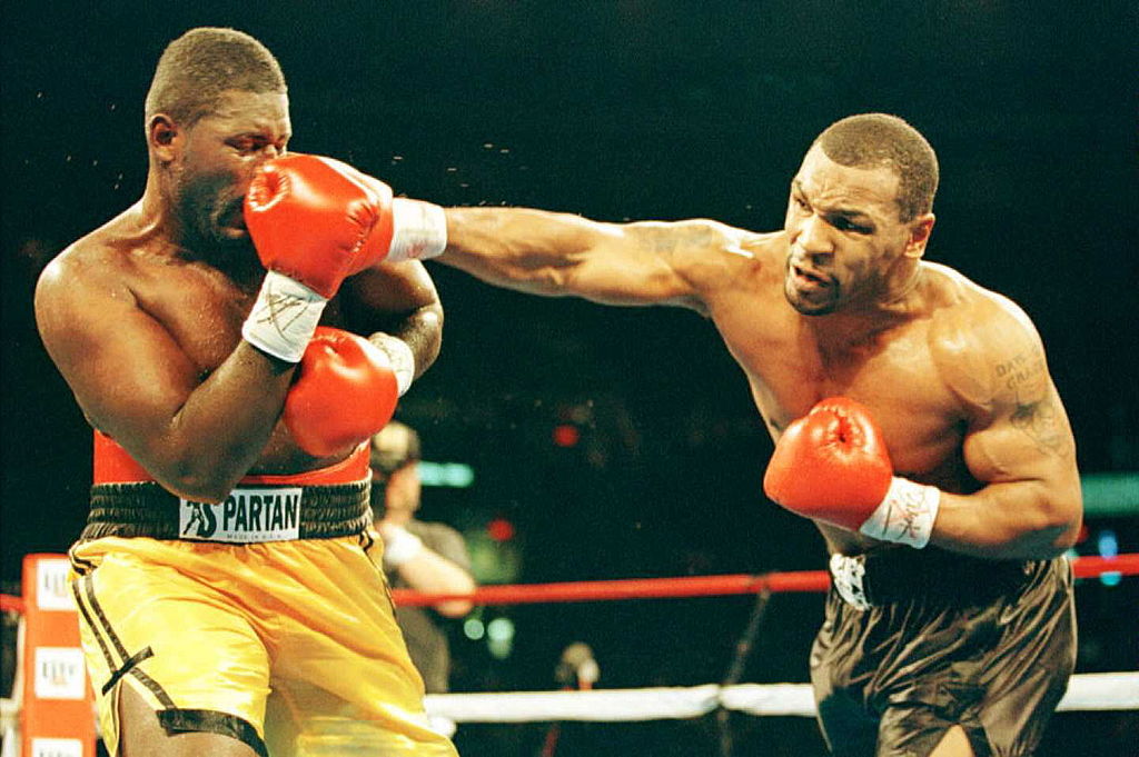 Heavyweight boxer Mike Tyson (R) lands a punch to