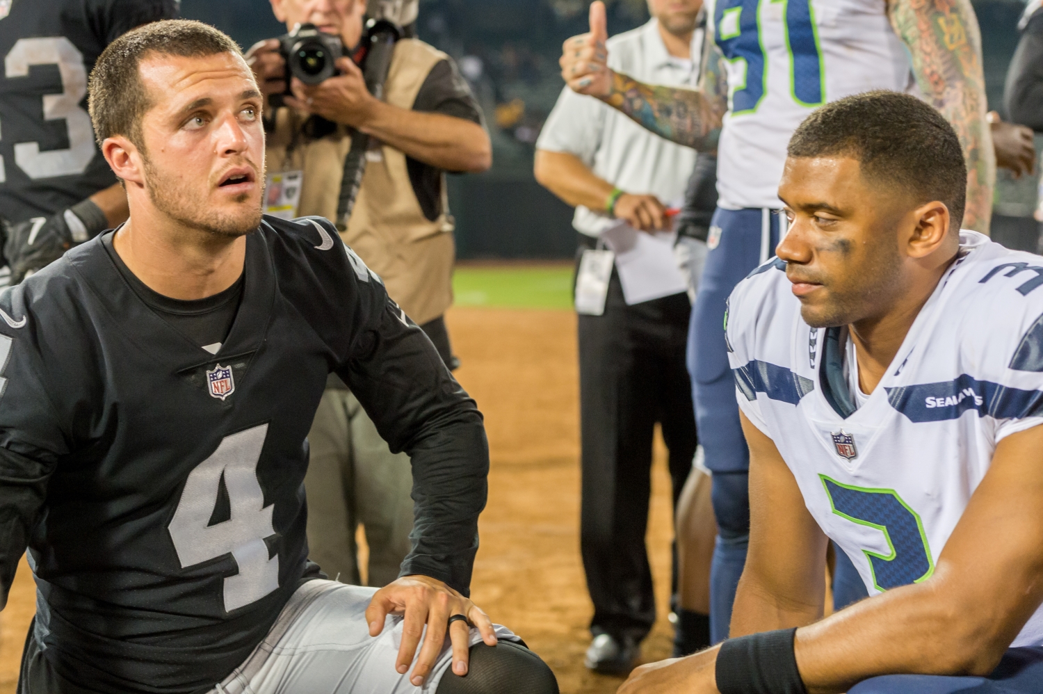 Derek Carr and Russell Wilson kneel in prayer following a game between the Raiders and the Seahawks in August 2017.