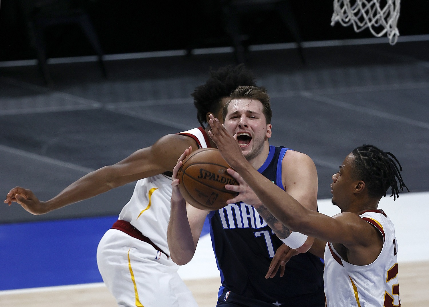 Luka Doncic of the Dallas Mavericks drives to the basket against Isaac Okoro and Collin Sexton of the Cleveland Cavaliers on May 7,