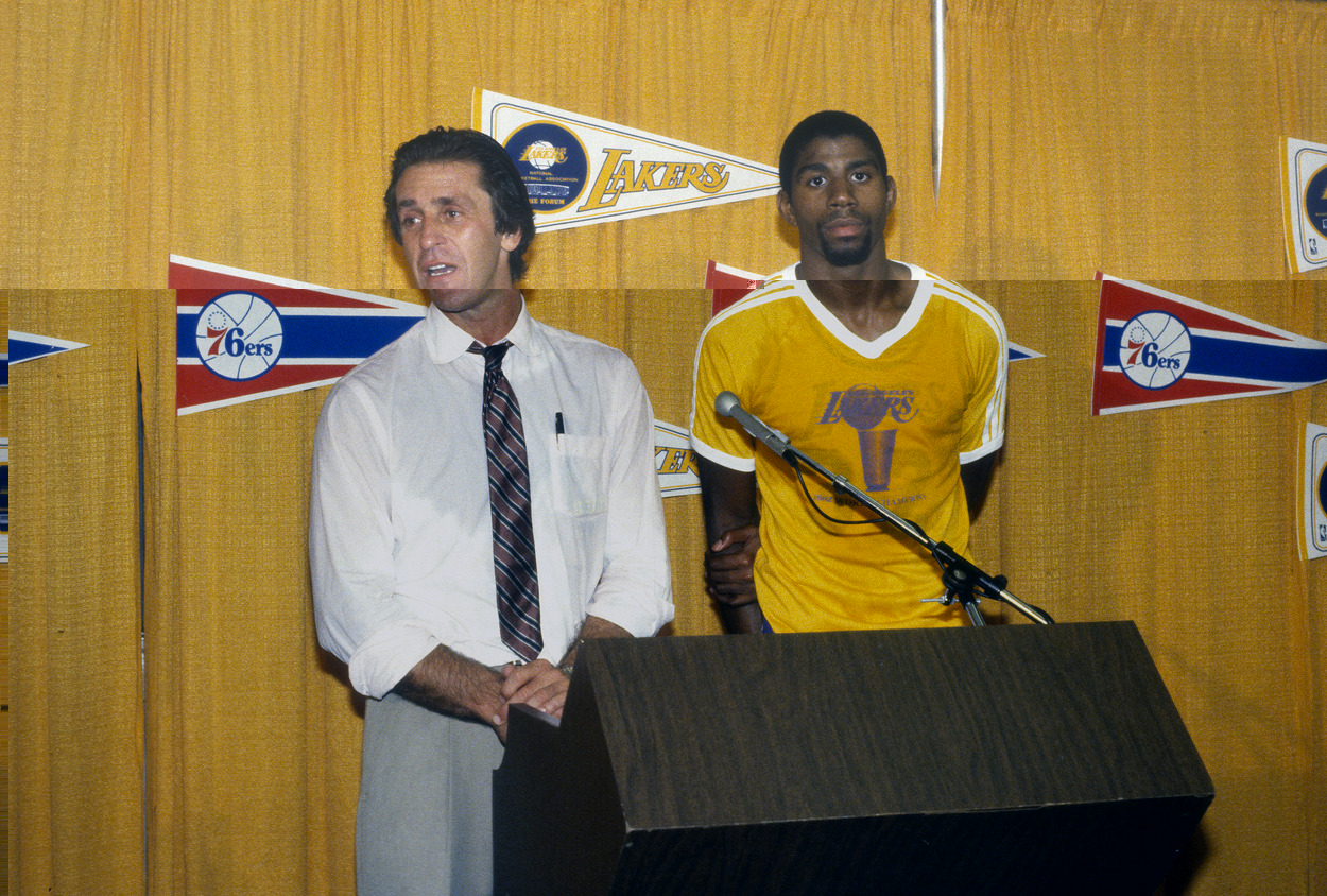 Former Los Angeles Lakers head coach Pat Riley stands next to Magic Johnson and addresses the media.