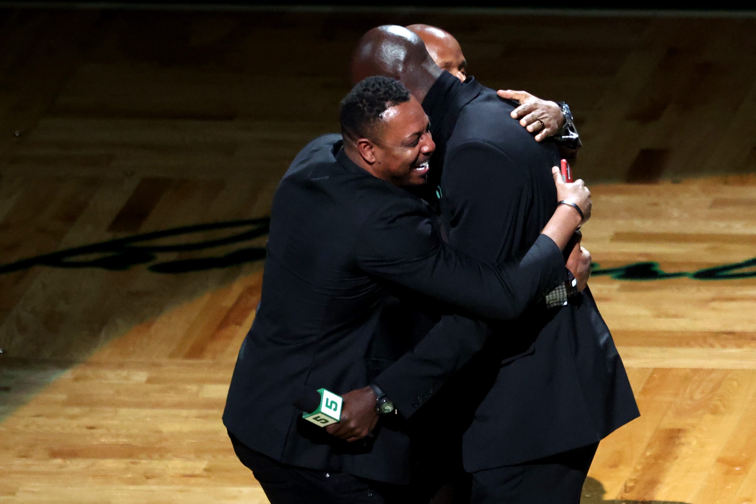 Former Boston Celtics players Paul Pierce and Ray Allen hug Kevin Garnett.
