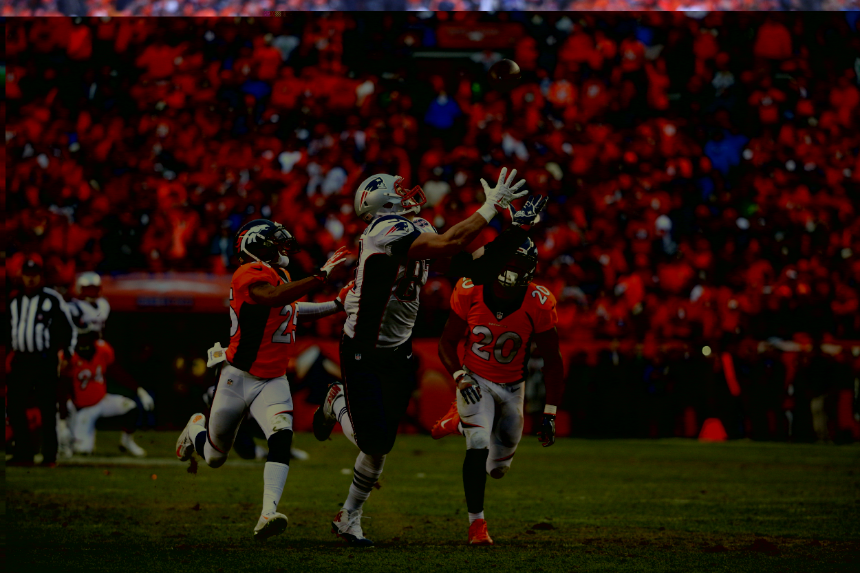 New England Patriots tight end Rob Gronkowski catches a pass over Denver Broncos cornerback Chris Harris (25) and Denver Broncos defensive back Josh Bush (20).