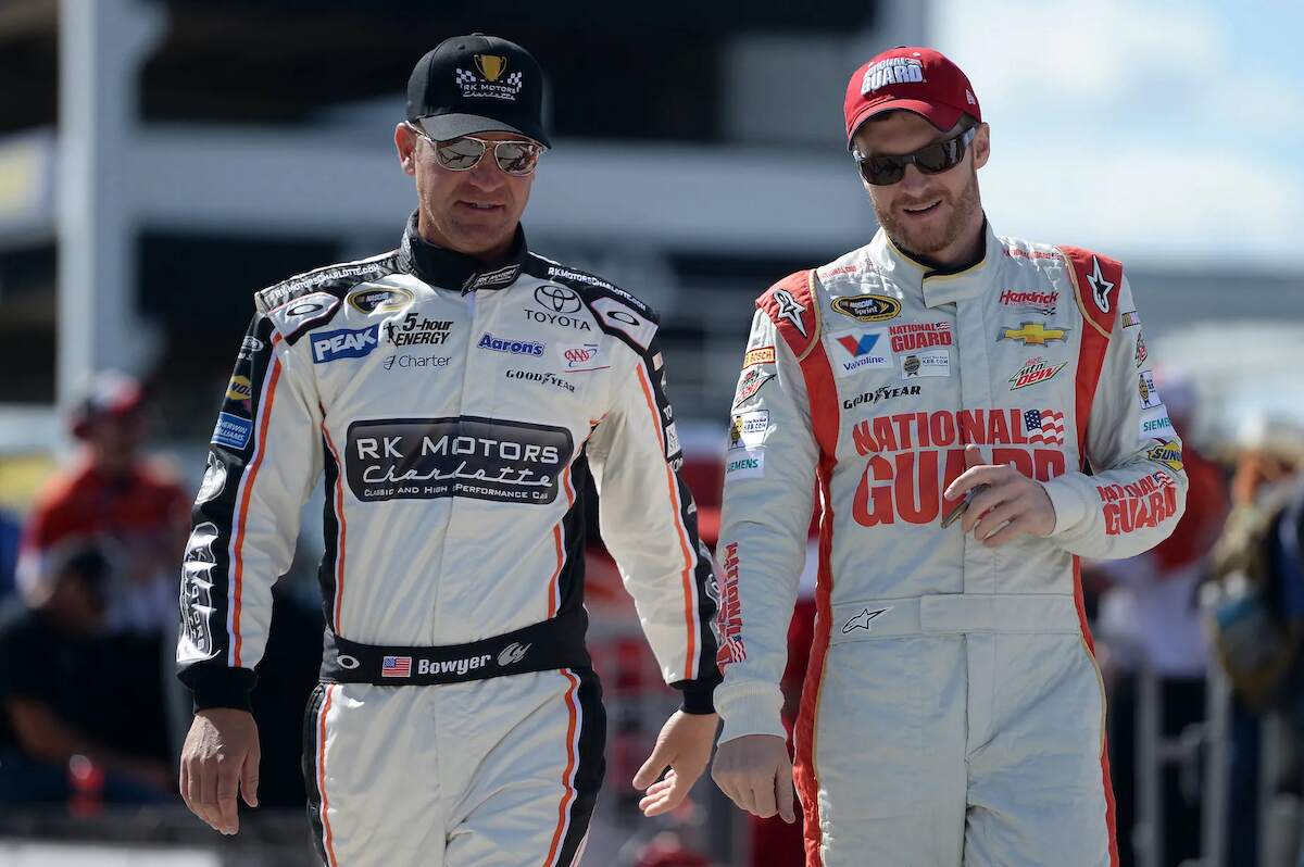 Clint Bowyer and Dale Earnhardt Jr. walk together ahead of a NASCAR race